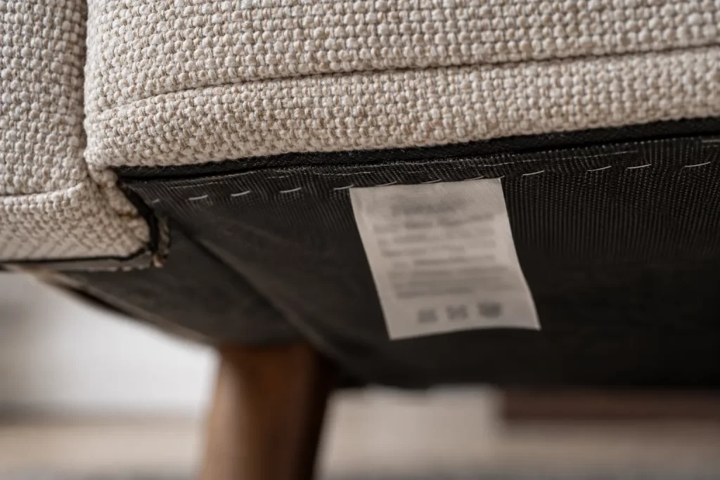 Generic sofa care label and upholstery stitching viewed close up